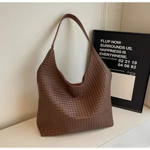 Detailed close-up showing the intricate cross-woven texture of the dark brown leather tote
