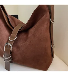 Detailed close-up of dark brown suede tote bag featuring silver metal buckle and zipper