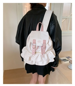 Detail of pink polka dot backpack featuring double-layered ruffle trim and drawstring closure