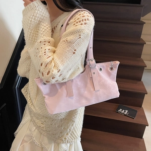 Pink retro rivet shoulder bag with adjustable strap worn by a model on stairs