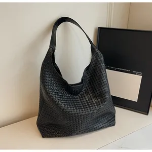 Detailed view of black woven faux leather texture on large capacity hobo shoulder bag
