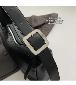Detail view of the silver adjustable buckle and fine leather texture of the shoulder bag