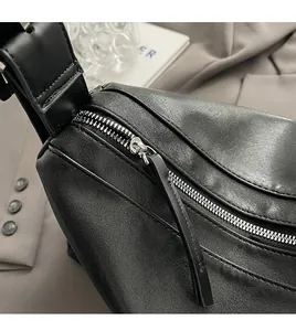 Macro shot of silver metal zipper on premium black leather with textured finish