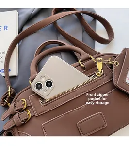 Macro shot of front zipper pocket on brown leather bag with phone storage space