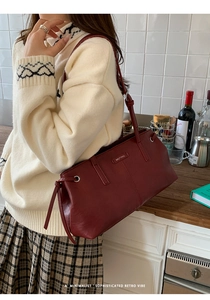 Detail of burgundy leather shoulder bag with Muting logo and decorative side drawstrings
