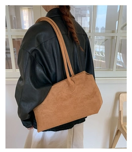 Braune Wildleder-Einkaufstasche an einem Modell mit schwarzer Lederjacke im Streetstyle