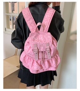 Detail of pink leopard print backpack with decorative ruffle trim and leather straps