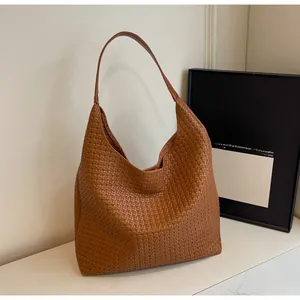 Macro detail of caramel woven leather tote bag with Intrecciato pattern craftsmanship