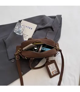 Spacious interior of brown Boston bag showing daily essentials and teddy charm detail