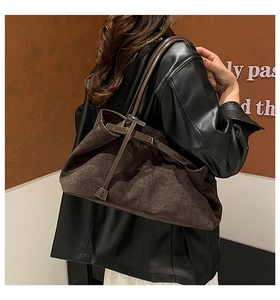 Dettaglio borsa tote in pelle scamosciata marrone scuro con anello metallico e coulisse