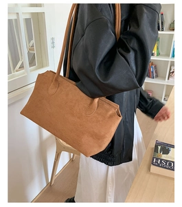 Close-up of a brown suede shoulder bag showing soft texture and premium craftsmanship
