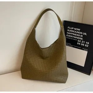 Detail of olive green woven tote bag showing premium synthetic leather texture