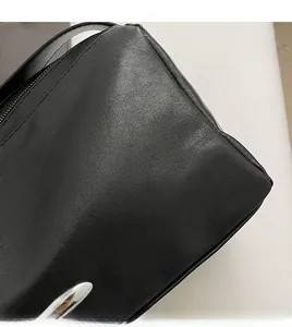 Detail view of premium black leather tote showing smooth texture and precision stitching