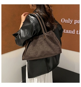 Dettaglio della grande borsa tote in pelle scamosciata marrone con manici in pelle