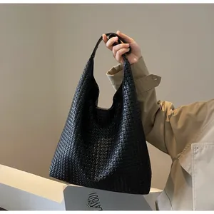 Close-up of the high-quality woven faux leather texture on this black oversized tote bag
