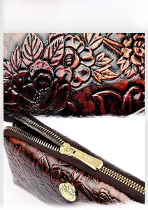 Close-up of embossed rose pattern on vintage leather clutch with gold metal zipper