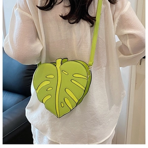 Detail of leaf-shaped crossbody bag featuring intricate vein patterns and bright green PU leather