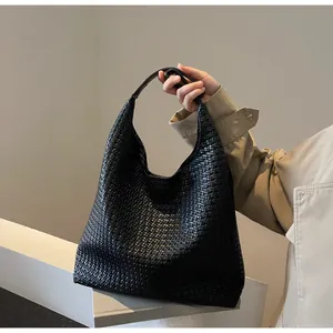 Detailed close-up of the black hand-woven leather texture on this large hobo shoulder bag