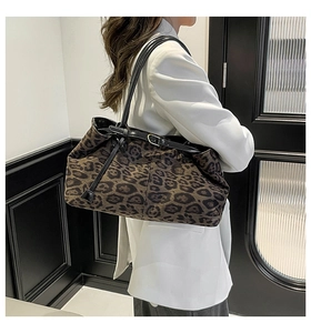 Dettaglio della borsa tote leopardata con tracolla regolabile in pelle indossata da modella
