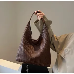 Detailed close-up of dark brown woven texture on large soft leather tote bag