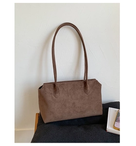Detailansicht der braunen Wildleder-Tragetasche mit verstärkten Schultergurten im Vintage-Stil