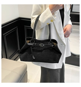 Detalle del bolso tote de ante negro mate con correas finas y hebilla decorativa