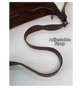 Dettaglio della tracolla regolabile con occhielli in argento su borsa tote marrone