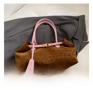 Close-up of leopard print handbag with pink leather strap and metal buckle detail