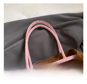 Detail of leopard print tote bag featuring pink handle and golden metal buckles