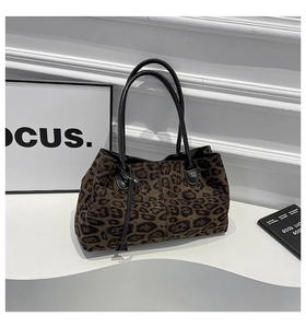 Dettaglio della borsa tote in pelle scamosciata leopardata con manici in pelle nera