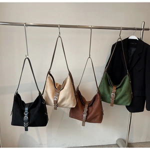Close-up of suede shoulder bags in four colors with vintage metal buckle details