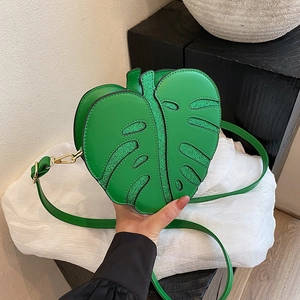 Green monstera leaf shaped crossbody bag with glitter texture and gold hardware