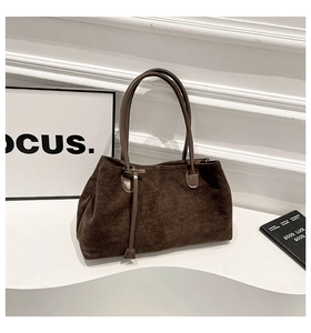 Dettaglio della borsa tote vintage in pelle scamosciata marrone con cuciture e manici