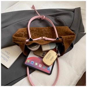Detail view of large leopard print tote bag with pink leather straps and spacious interior