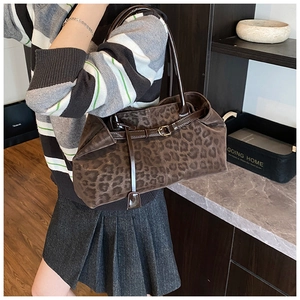 Macro detail of leopard print tote bag featuring faux suede texture and leather strap