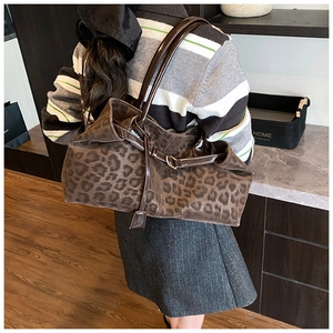 Detail of the leopard print tote bag with brown faux leather straps and velvety texture