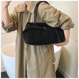 Detail of vintage leopard print tote bag with black leather straps on a trench coat
