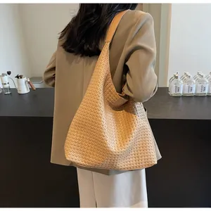 Detailed view of the intricate hand-woven leather texture on this large brown hobo tote bag