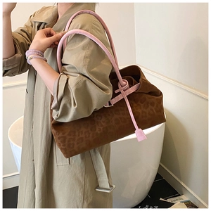 Detail of leopard print tote bag with pink handles styled on a khaki trench coat