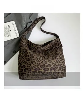 Macro shot of faux suede tote bag with leopard print texture and wide strap details
