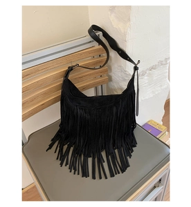 Dettaglio della borsa a tracolla in pelle nera satinata con lunghe nappe bohémien