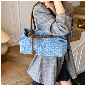 Dettaglio della borsa tote leopardata blu con tracolla in pelle marrone e fibbia