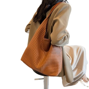 Vintage brown woven leather tote bag shown on a model for a large capacity daily look