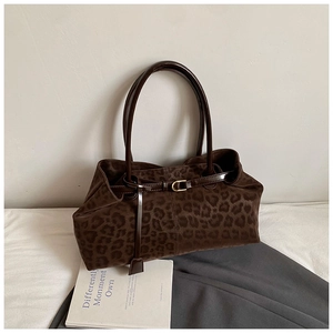 Close-up of leopard print tote bag with leather tie detail and long shoulder strap
