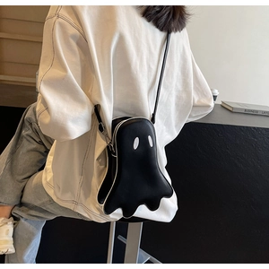Detailed side view of black ghost crossbody bag with adjustable strap worn by model