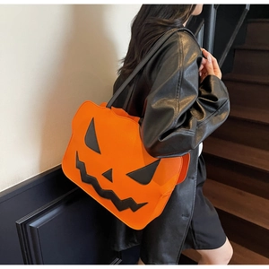 Detail of pumpkin-shaped tote bag in orange PU leather worn over the shoulder