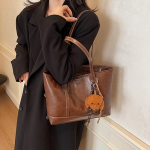 Retro dark brown leather tote bag for women shown with cute dog charm on shoulder