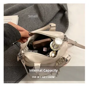 Top view of the interior capacity showing daily items in the cream boston bag