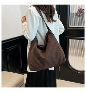 Detail view of the brown faux suede large tote bag showing soft texture and drape on model