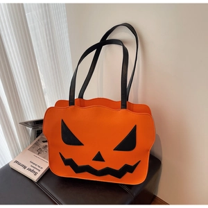 Close-up of bright orange pumpkin shoulder bag with Jack-o'-lantern face and black handle